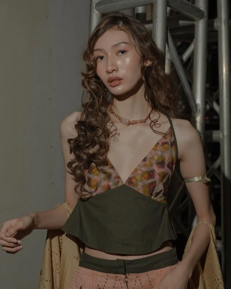 Model wearing a halter top with ikat cups over an olive linen peplum.
